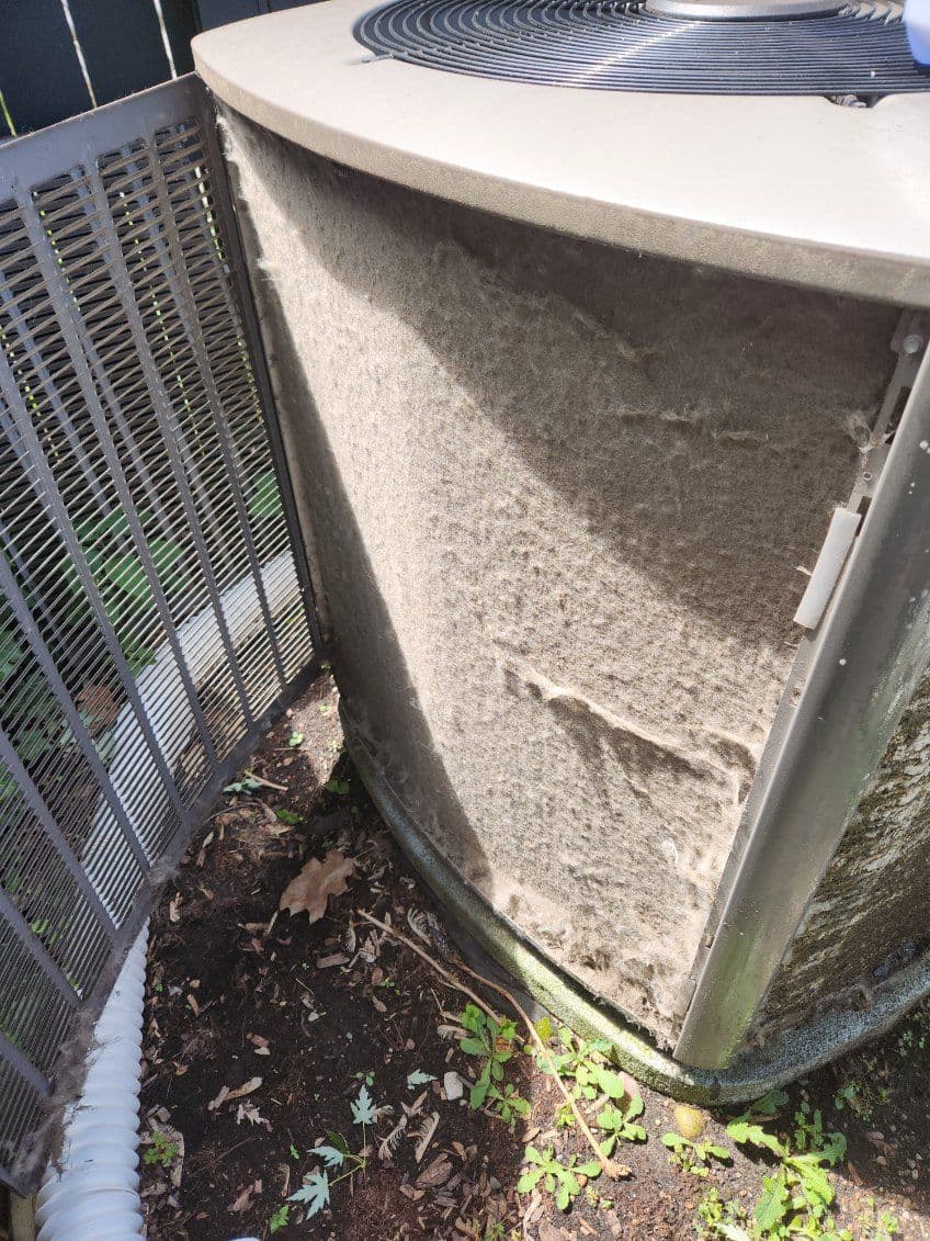 Dirty air conditioning unit showing dust buildup and grime on the exterior surface.